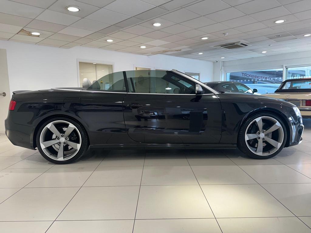 Side view of the Audi RS5 Cabriolet with 20-inch alloy wheels and carbon spoiler.