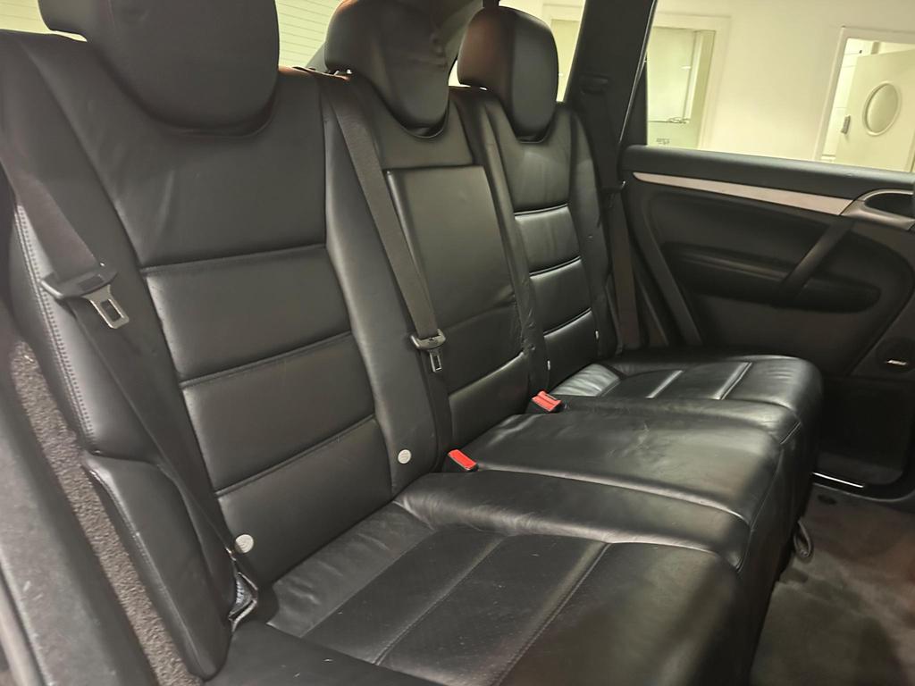 Luxurious interior of the Porsche Cayenne featuring leather sports seats and panoramic sunroof.