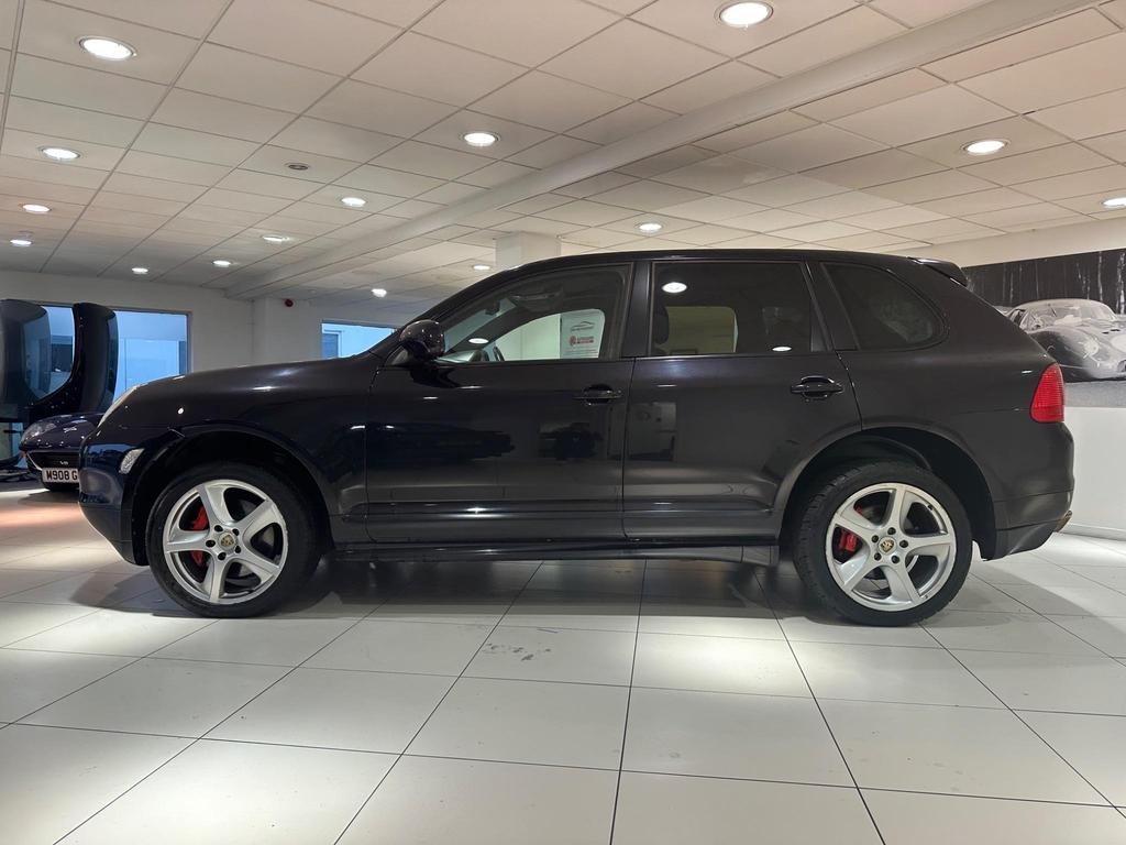 Front view of the 2005 Porsche Cayenne in sleek black, showcasing its iconic design and Sport Pack features.