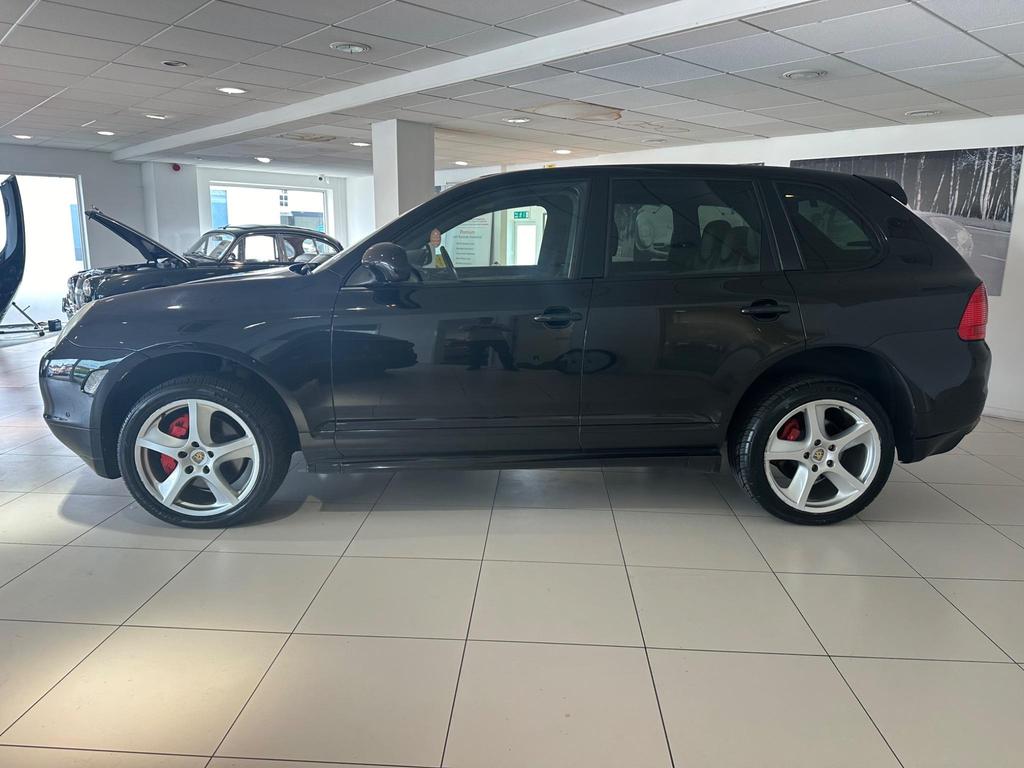 Front view of the 2005 Porsche Cayenne in sleek black, showcasing its iconic design and Sport Pack features.