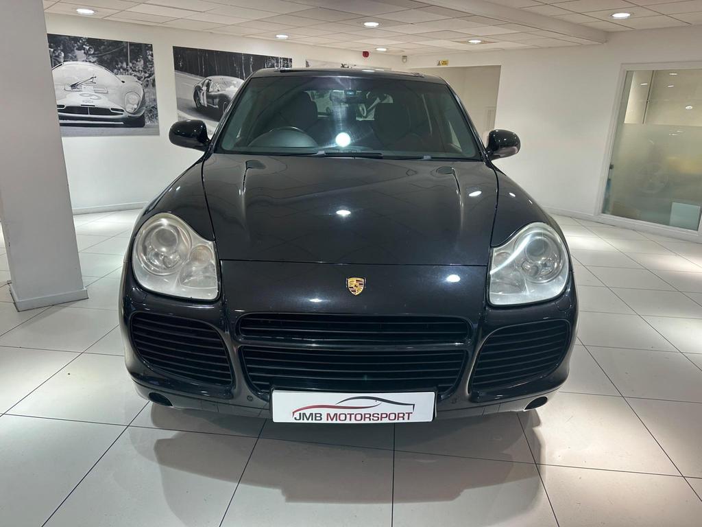 Front view of the 2005 Porsche Cayenne in sleek black, showcasing its iconic design and Sport Pack features.